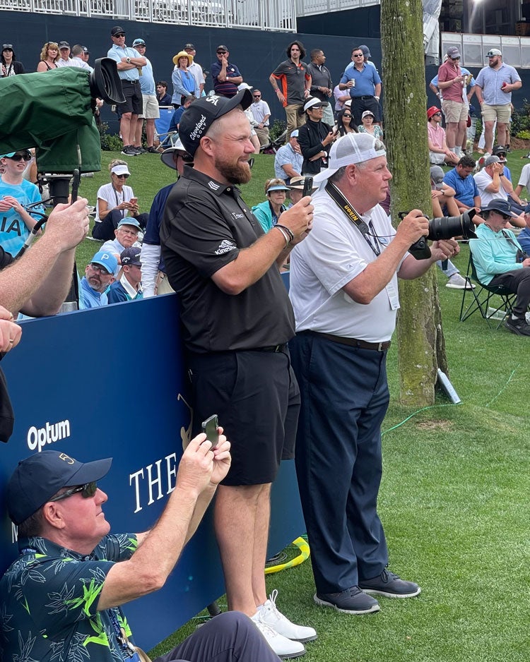 Shane Lowry watches his caddie tee it up.