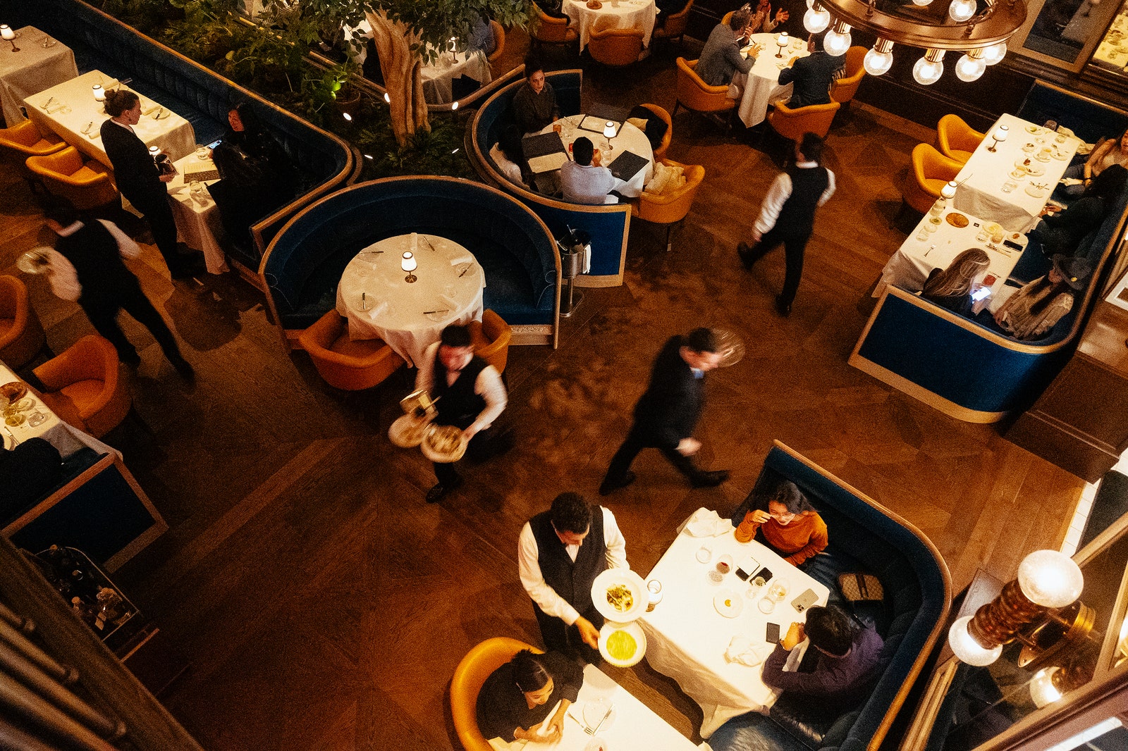 An overhead shot of the dining room of the restaurant with servers in formal wear.