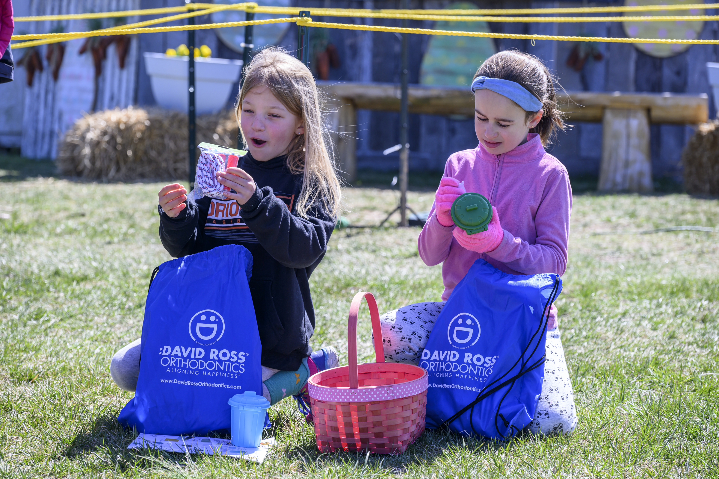 Two girls go through their gift bags during the Coppermine Eggstravaganza at Cascade Park in Hampstead. (Thomas Walker/Freelance)
