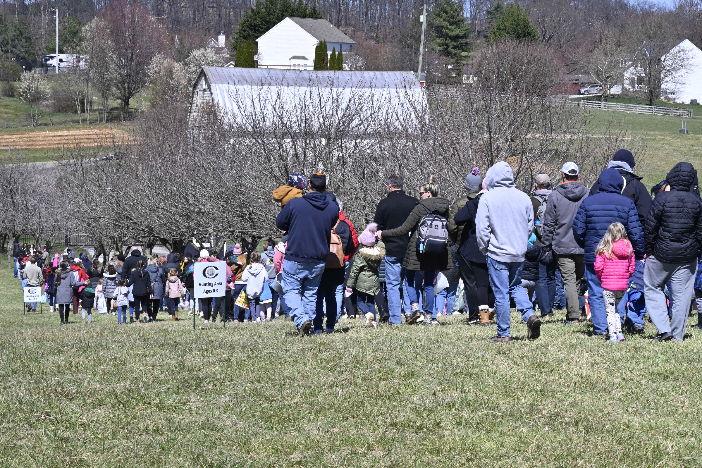 Families walk to the starting area before the Easter egg hunt during the Coppermine Eggstravaganza at Cascade Park in Hampstead. (Thomas Walker/Freelance)