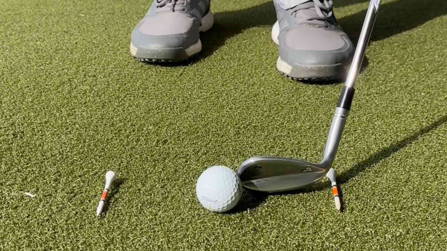 Golf teacher Nick Kumpis shows a clever trick that uses two tees to help find the low point of the golf club and improve contact