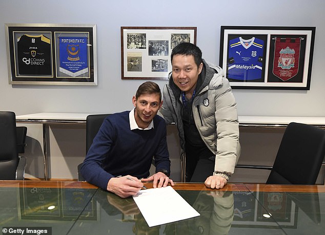 Sala signing for Cardiff in 2019, with CEO Ken Choo, holding a silver pen. Now Cardiff are launching a fresh legal case demanding compensation for their Premier League relegation