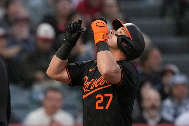 Baltimore Orioles' James McCann gestures as he scores after hitting...