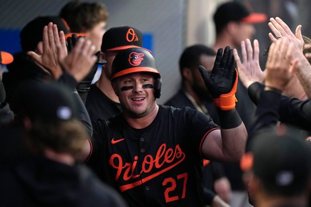 Baltimore Orioles' James McCann is congratulated by teammates in the...