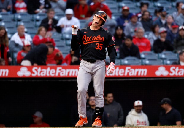 Adley Rutschman #35 of the Baltimore Orioles reacts after fouling...