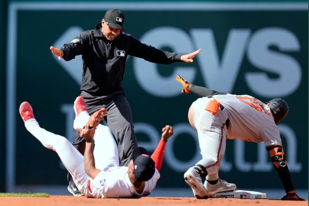 Boston Red Sox's Enmanuel Valdez lies on the field as...