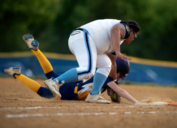 Perry Hall base runner Kylie Smith is picked off first...