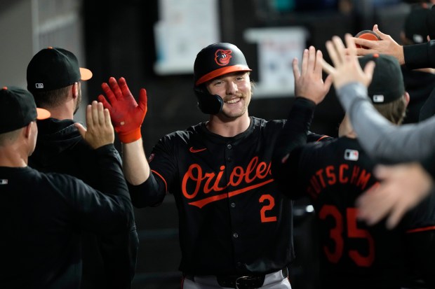 Baltimore Orioles' Gunnar Henderson is greeted in the dugout after...