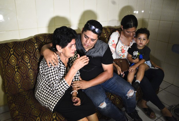 Rosa Emerita Sandoval Paz, madre de Maynor Suazo, es consolada por otros familiares en la Funeraria Amor Eterno, en San Pedro Sula, el martes. 