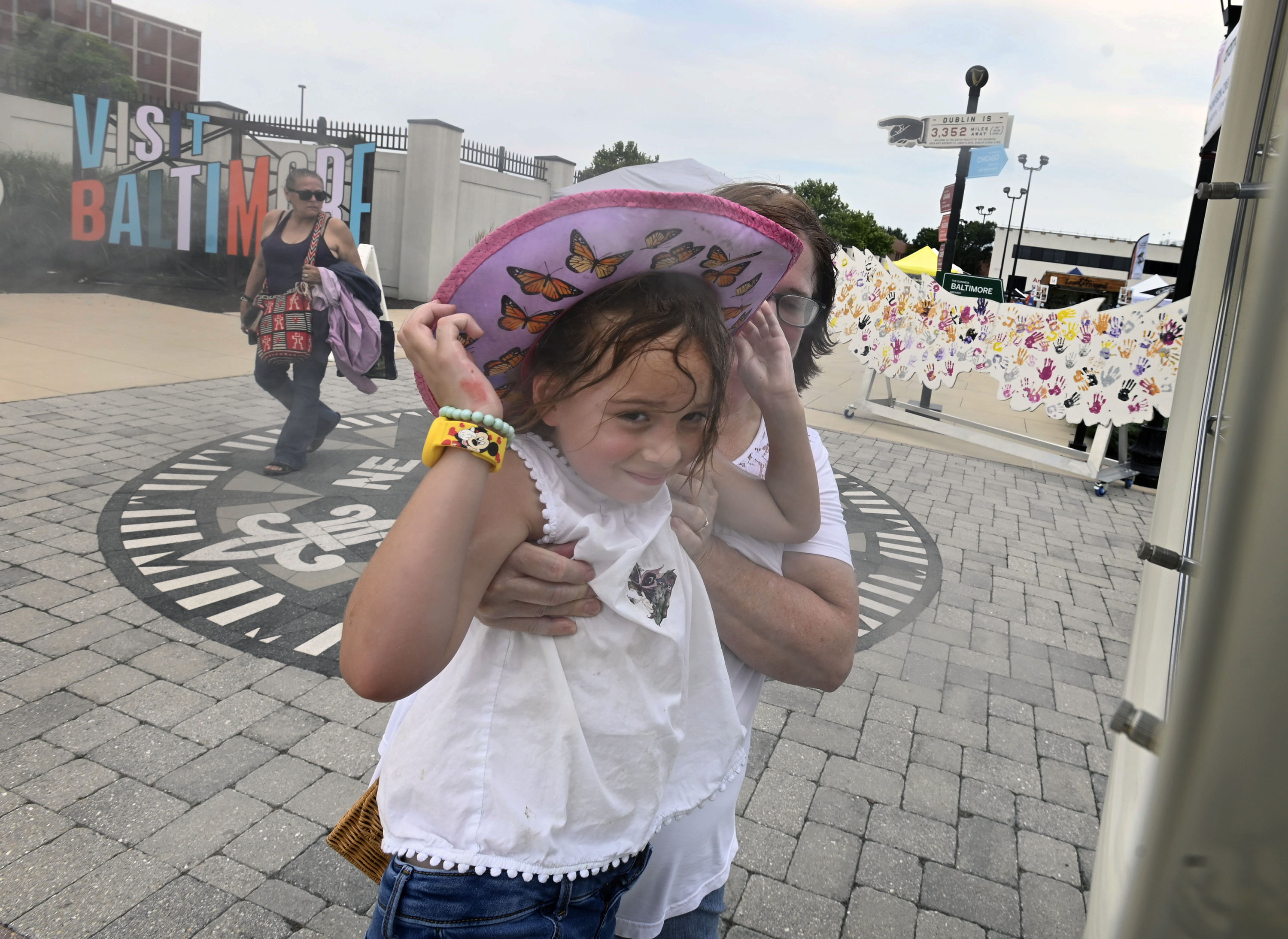 Natalie Bookhultz, 6, of Elridge, is lifted by grandma Darcey to a misting fan to cool off during Baltimore County's Arts & Drafts Summer Music and Arts festival. The free two-day event presented by the nonprofit Baltimore County Arts Guild (BCAG) features curated artist vendors, live music, fun activities for all ages and specialty food & beers from host sponsor, Guinness Open Gate Brewery.