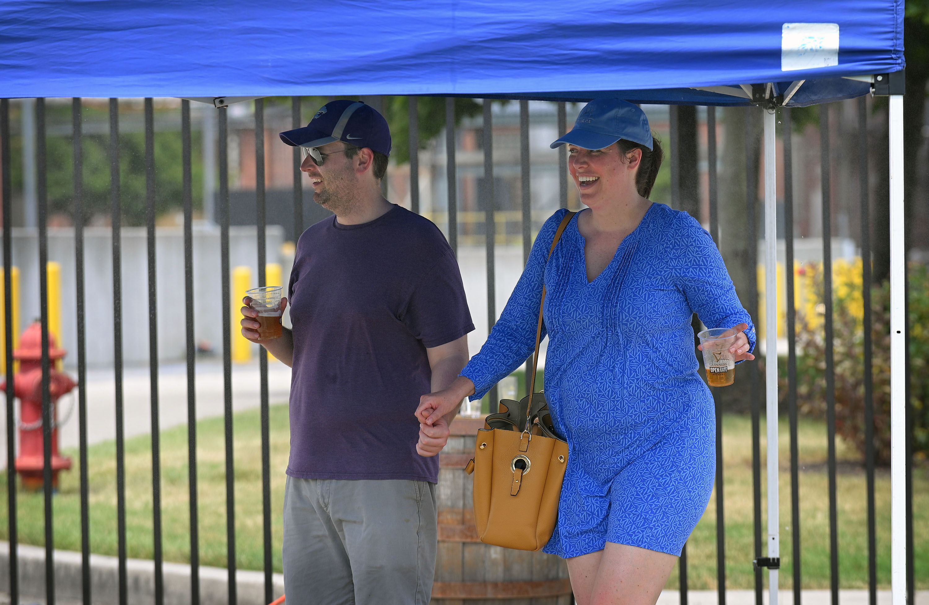 Travis Severt, left, of Baltimore, and girl friend Brittney Luberda cool off from the heat in a misting tent during Baltimore County's Arts & Drafts Summer Music and Arts festival. The free two-day event presented by the nonprofit Baltimore County Arts Guild (BCAG) features curated artist vendors, live music, fun activities for all ages and specialty food & beers from host sponsor, Guinness Open Gate Brewery. (Kenneth K. Lam/Staff)