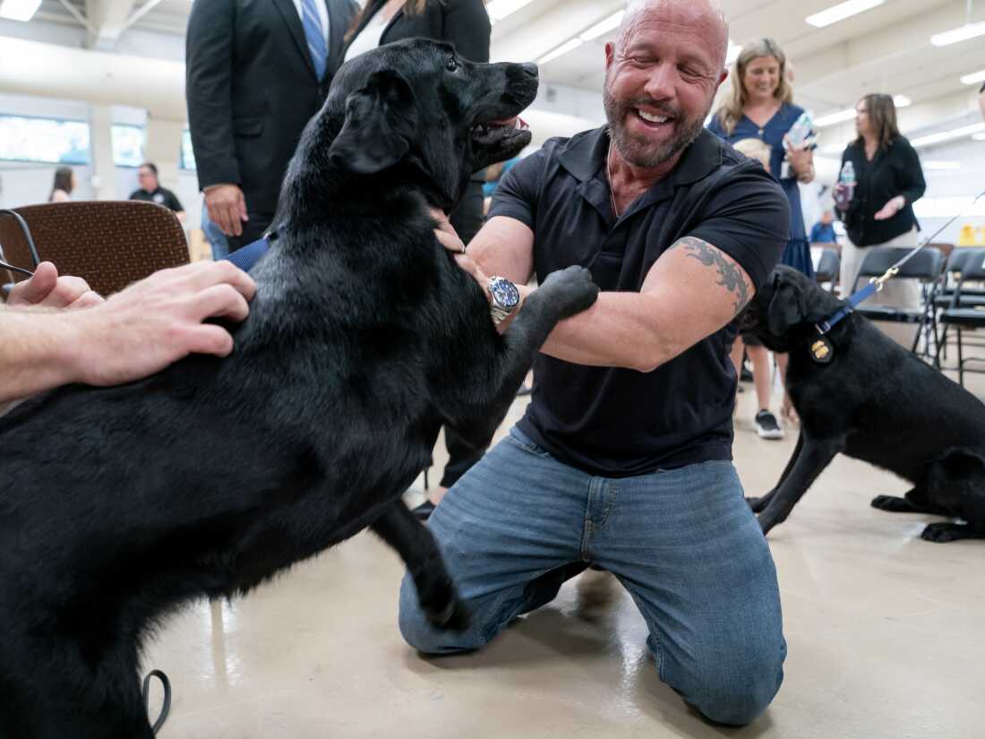 Carl Roth, a senior instructor with Puppies Behind Bars, greets K-9 Tara, who he worked with before her training, during a graduation ceremony for Bureau of Alcohol, Tobacco, Firearms and Explosives (ATF) Special Agent Canine Handlers and their dogs at the ATF training facility in Front Royal, Va., on June 21.