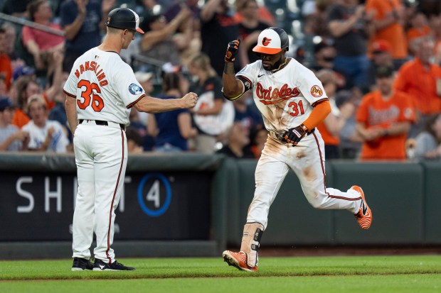 The Orioles' Cedric Mullins celebrates a home run with third...