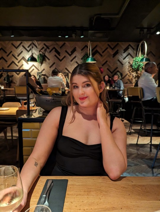 Freya Ruth drinking wine in a restaurant 