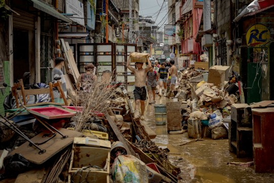 MANILA, PHILIPPINES - JULY 25: Residents clean their muddied homes after they were flooded by Typhoon Gaemi on July 25, 2024 in Marikina, Metro Manila, Philippines. Monsoon rains, intensified by Typhoon Gaemi, have caused flooding and landslides throughout the Philippines, resulting in at least 22 deaths and displacing over 600,000 people. The typhoon, which also left two dead in Taiwan, did not make landfall in the Philippines but enhanced monsoon rains. In the region around the capital Manila, government work and schools were suspended due to severe overnight flooding. (Photo by Ezra Acayan/Getty Images)