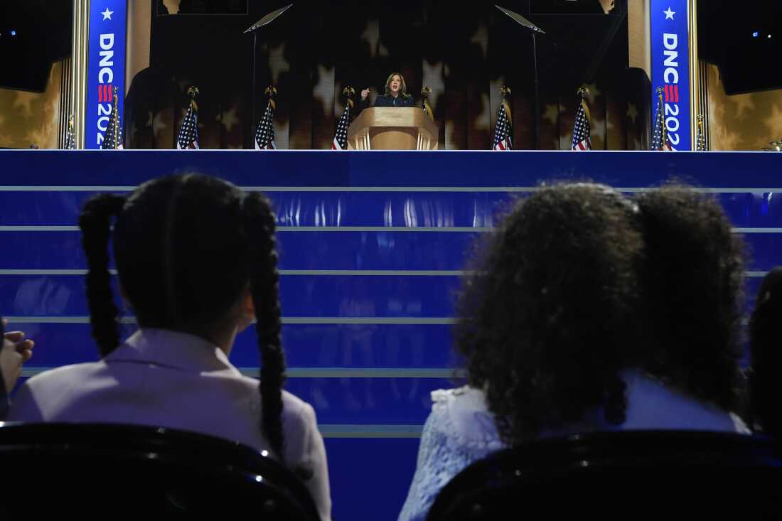 Vice President Kamala Harris speaks as her grand-nieces Amara Ajagu, left, and Leela Ajagu watch during the Democratic National Convention on Aug. 22, 2024, in Chicago.