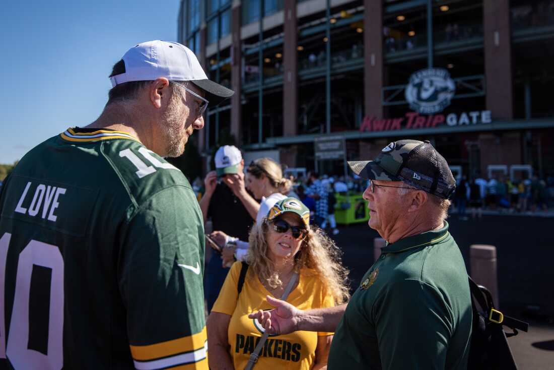 Democratic Party of Wisconsin Chairman Ben Walker, left, speaks to Denise Gaumer Hutchison, center, a Democratic voter from Green Bay, outside Lambeau Field on Sunday, Sept. 29.