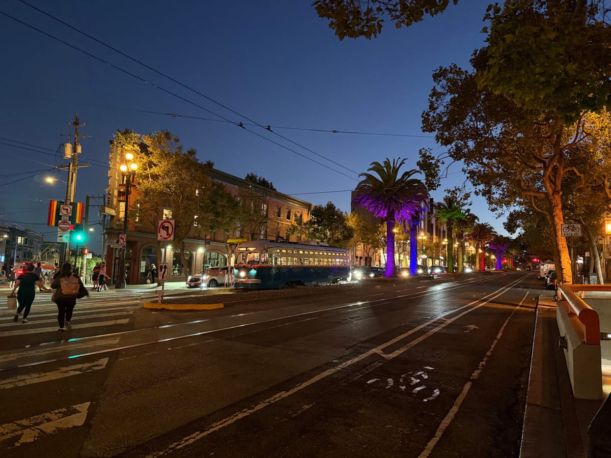 A street in San Francisco featuring a streetcar and trees throughout