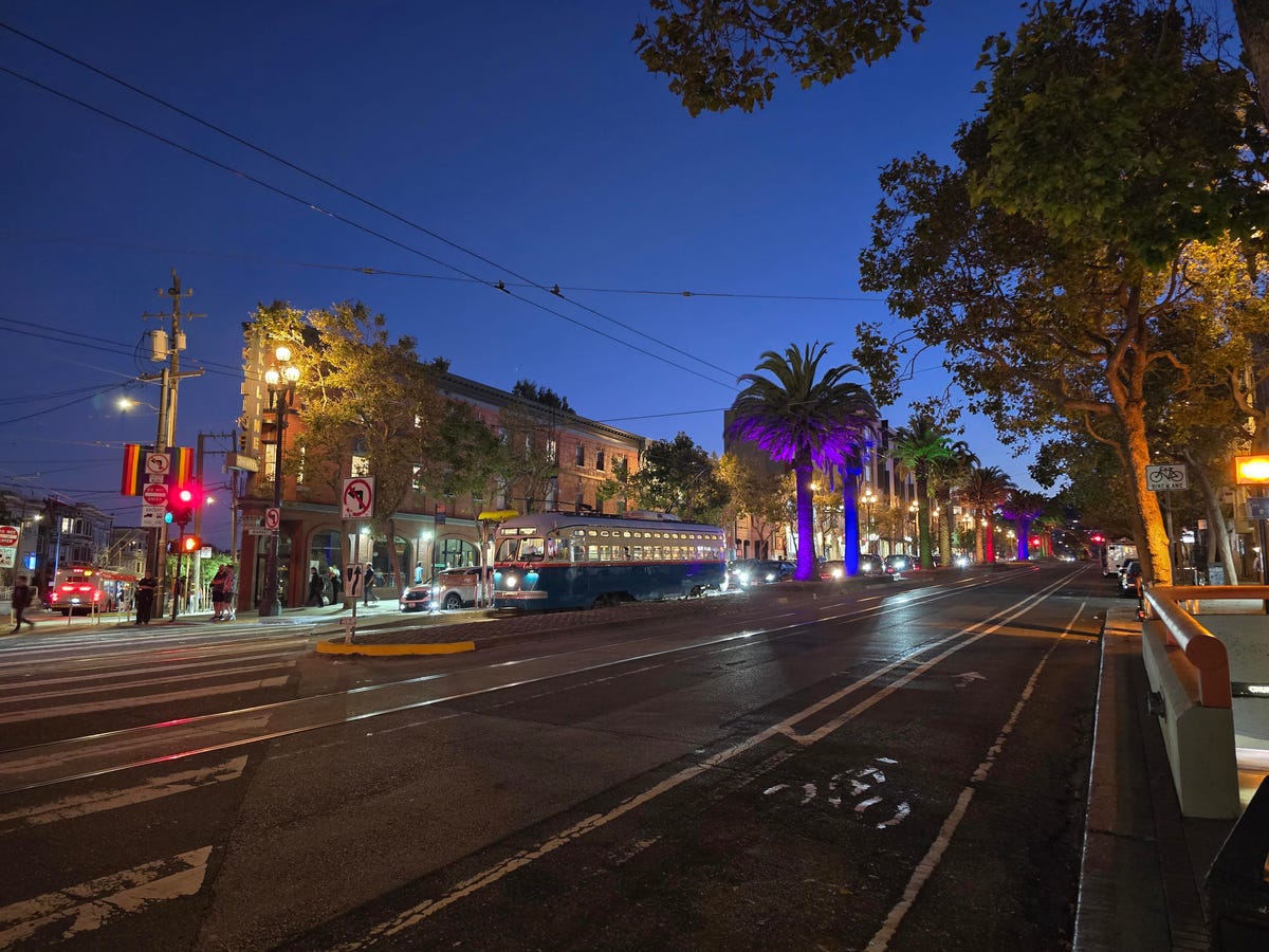 A street in San Francisco featuring a streetcar and trees throughout