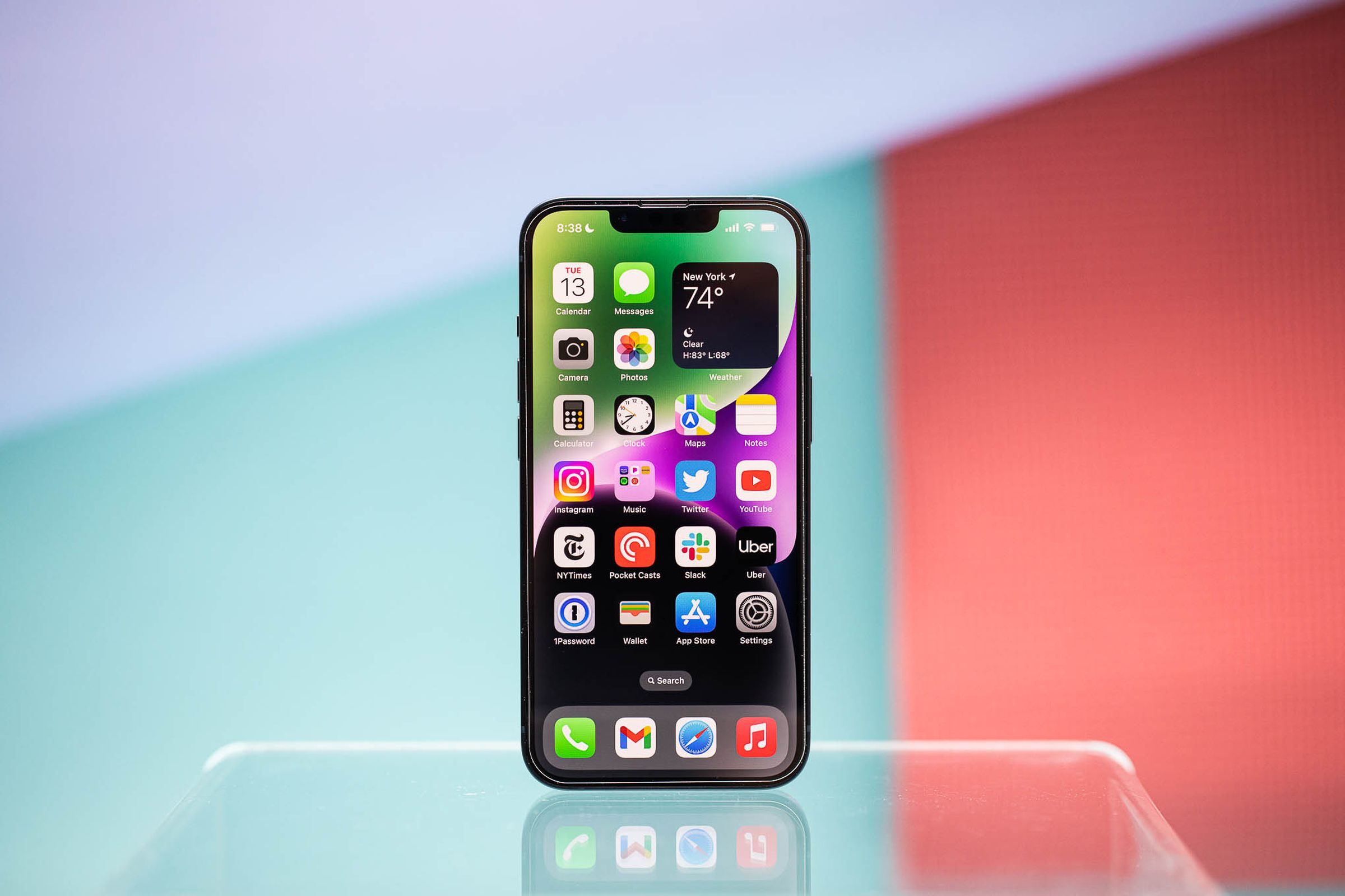 An iPhone 14 sitting upright on a table.