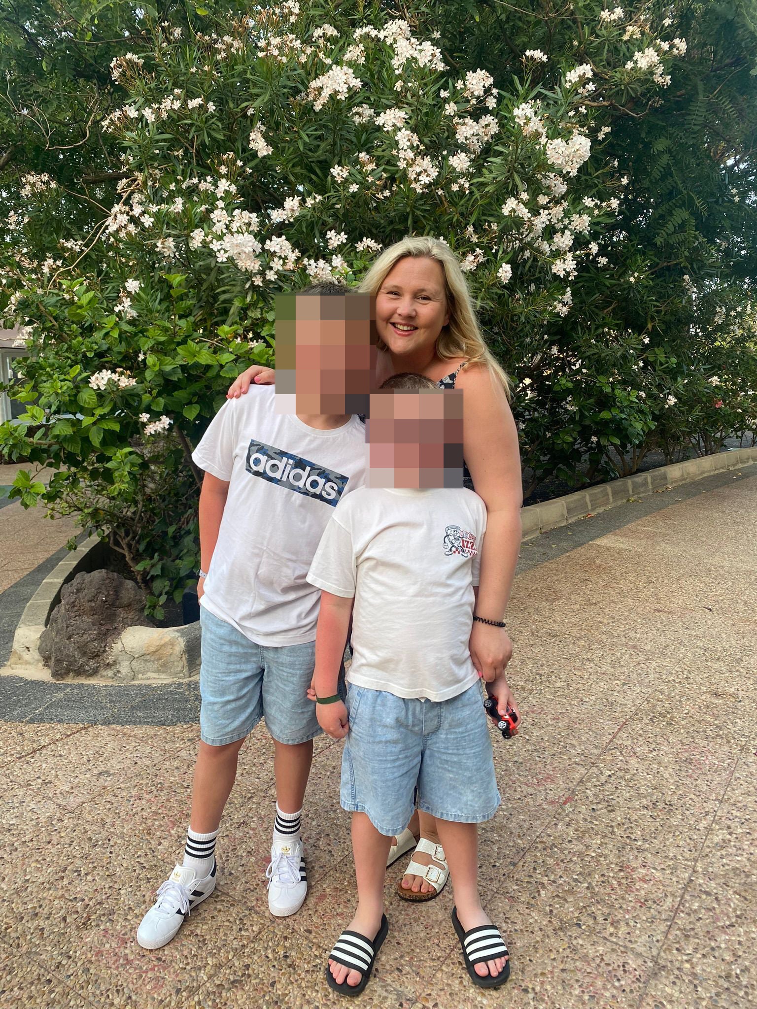 Charlie pictured with her two boys whose faces are blurred to protect their privacy