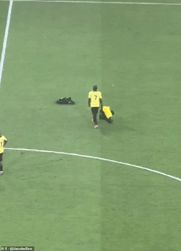 The Al-Ittihad star cleared scarves and flags off the pitch while his team-mates had a break