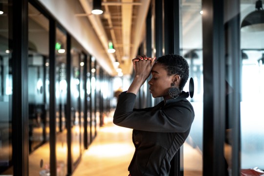 Worried young business woman at corridor office