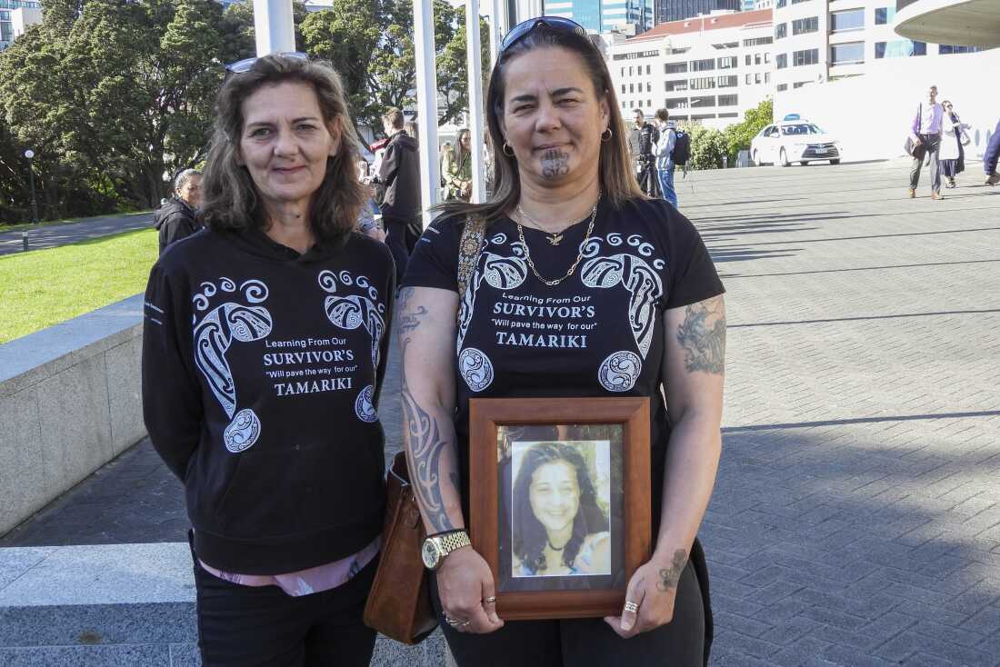 Gina, right, and Tanya Sammons hold a photo of their late sister Alva as they arrive at Parliament House in Wellington, New Zealand, ahead of the apology to the survivors of abuse in state, faith-based and foster care over a period of seven decades.