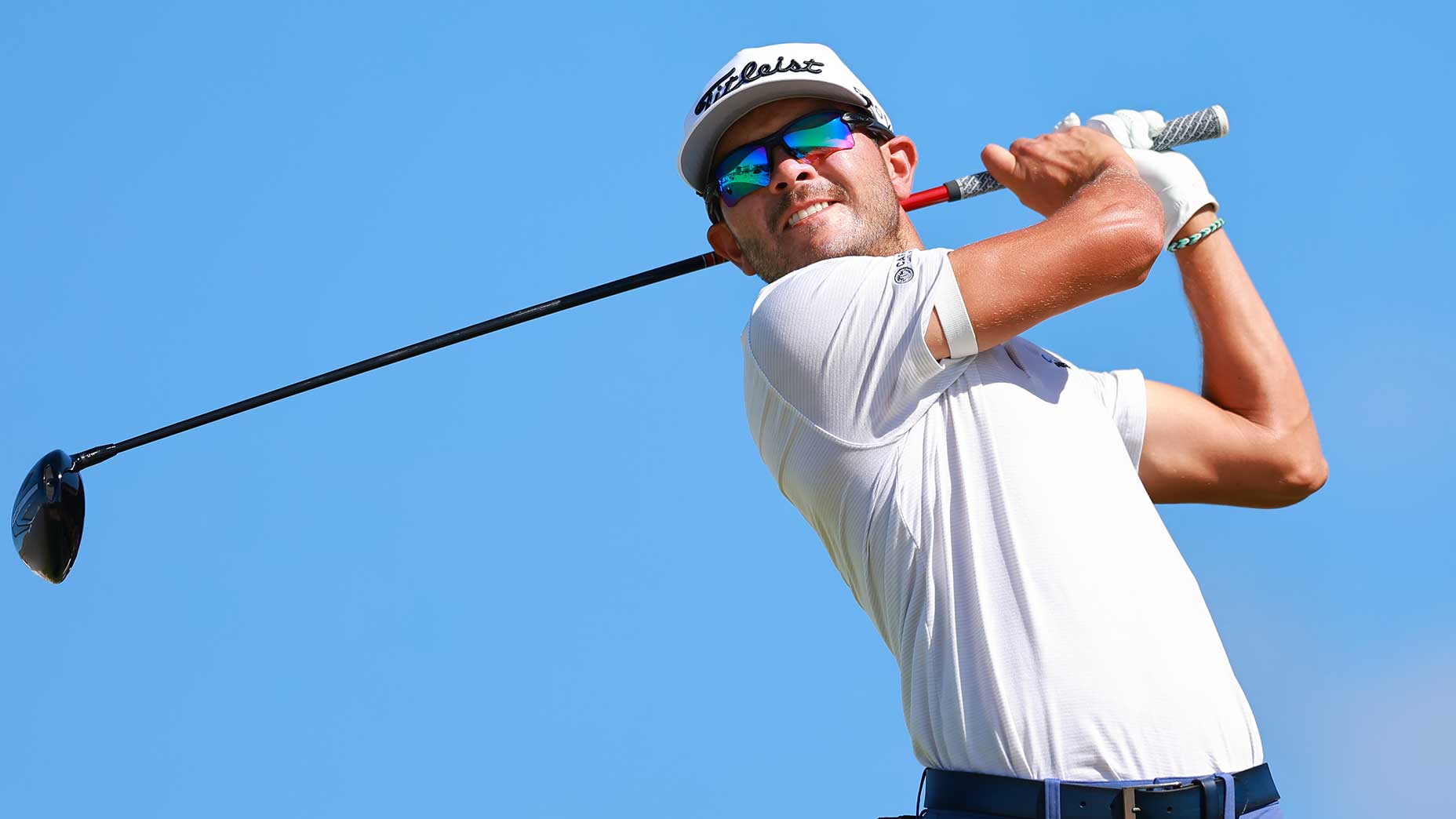 raul pereda swings driver in white shirt and hat at the Butterfield Bermuda Championship.