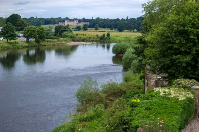 July 20, 2024 -Kelso, Scotland: View of the Tweed River from Kelso Bridge in Kelso, Scotland. Floors Castle can be seen in the distance.