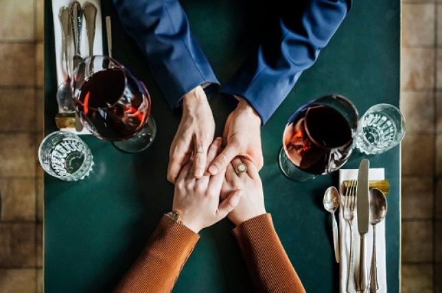 Aerial View Of Couple Holding Hands At Restaurant Table