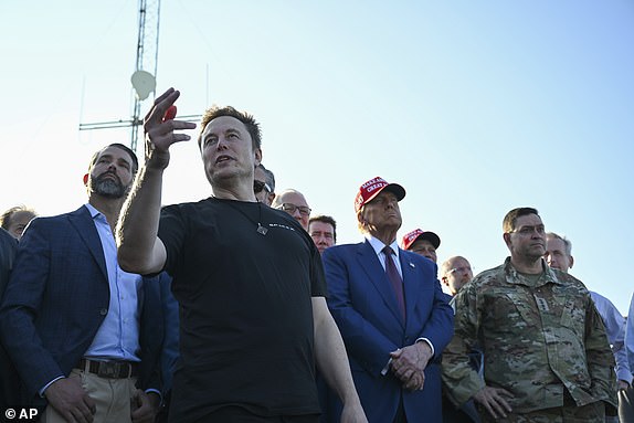 Elon Musk speaks as President-elect Donald Trump and Donald Trump Jr., left, listen before the launch of the sixth test flight of the SpaceX Starship rocket Tuesday, Nov. 19, 2024 in Boca Chica, Texas. (Brandon Bell/Pool via AP)